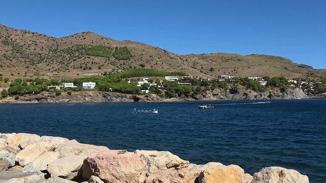 Boats glide on water by Spain's coast