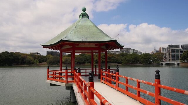 Ohori Park panorama in Fukuoka, Japan, Chuo-ku ward, Kyushu island, with pond, Ukimi-do pavilion, bridges and city skyline near Maizuru Park, lake and promenade in a spring sunny day
