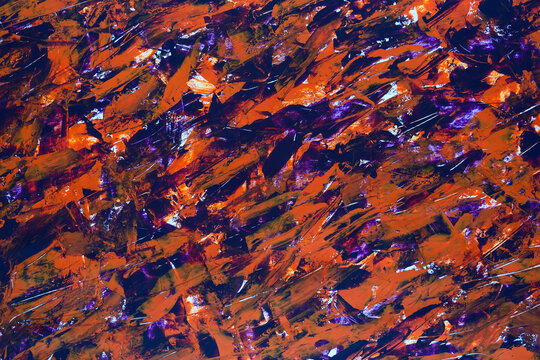 Vibrant shards swirl in fiery orange and deep purple hues. Glassy fragments catch light, forming a dynamic, textured surface. Abstract pattern evokes energy