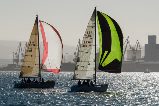 Two racing sailboats with colorful spinnakers in Santander Bay, Spain