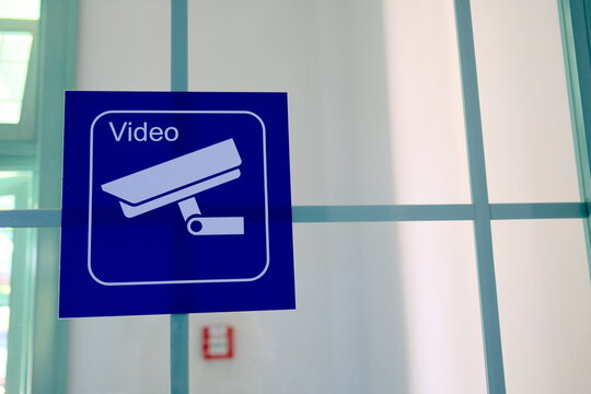 Close-up of a camera sign at a railway station representing a video recording in progress