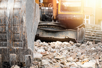Close-up of an excavator bucket on demolition debris in sunlight © Burak