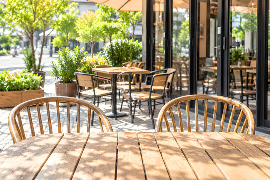 Empty wooden tables on a sunny outdoor cafe patio