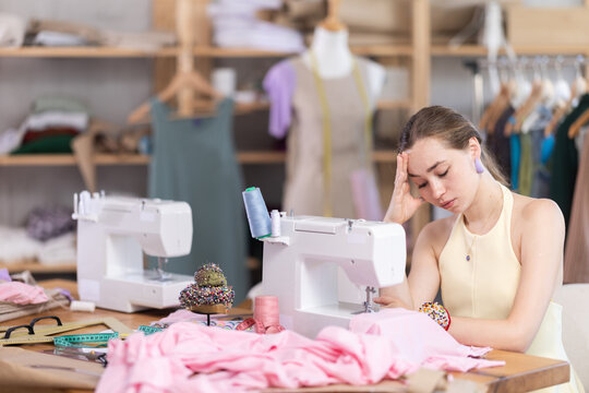 Tired seamstress working at a sewing machine