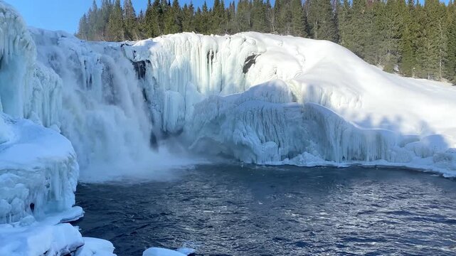 Ice-covered waterfall next to snow-covered trees under a cloudless sky, winter, Sweden's highest waterfall, T&auml;nnforsen, &Aring;re&auml;lven, Are, J&auml;mtland, Sweden