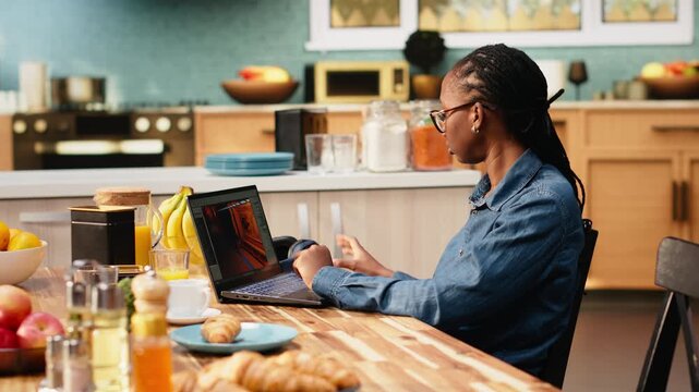 Young woman game developer with headset operates interactive gaming software, using visual effects and computer science. Specialist does 3D modeling and user interface development.