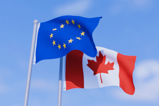 European Union and Canadian flags waving together against a blue sky, symbolizing international relations, bilateral trade agreement, diplomatic alliance, cooperation, and partnership.