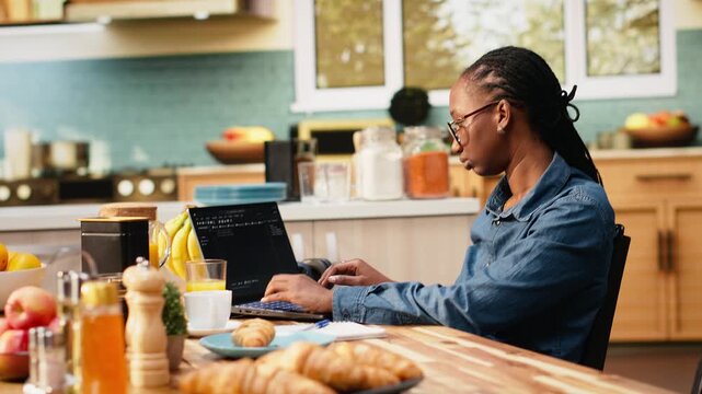 One person coding on laptop in kitchen representing remote work