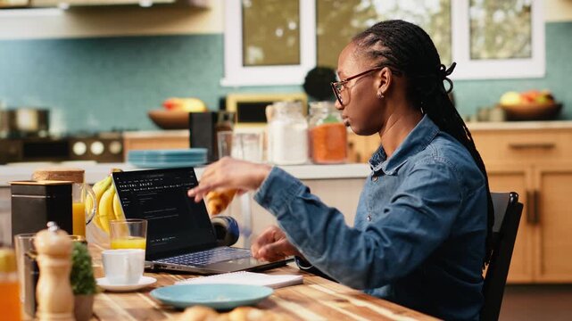 Adult woman uses laptop to write programming code and develop software. Programmer focuses on debugging scripts, analyzing data and working with a terminal window during digital coding work.