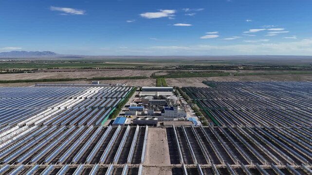 Panoramic view of parabolic trough solar thermal power plant in vast desert landscape