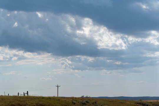 Prairie and phone poles with dramatic stormcloud backdrop