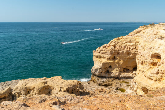 Golden coastal cliffs of Algarve Portugal with blue sea