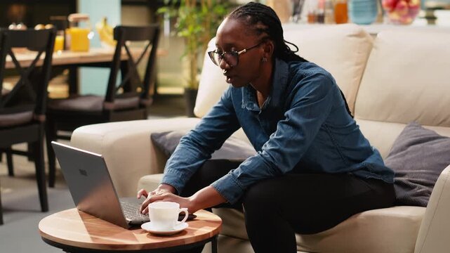 Young adult singing aloud on couch and solving remote tasks, being relaxed and enjoying stress-free telecommuting, gen z woman being silly.