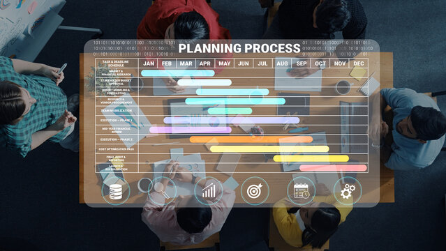 A group of professionals discusses a planning process, surrounded by a Gantt chart on a digital screen, showcasing project timelines and strategies for effective management. Nascent