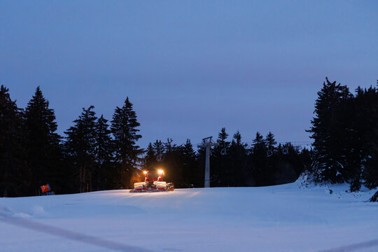 Snow grooming machine clears the ski slope during early morning hours near Mount Hood in Oregon before skiers arrive