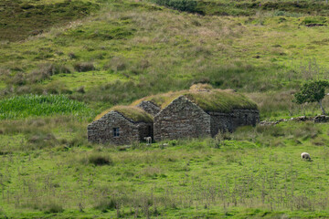 Old traditional stone farm buildings with grass roofs in Scotland © Raisa