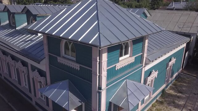 Rising aerial along teal mansion and weather vane