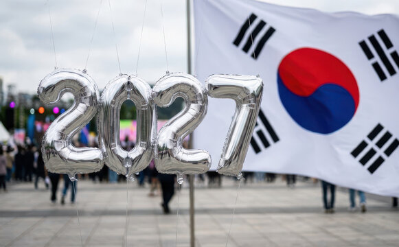 Silver balloons forming 2027 in front of the South Korean flag representing future planning and national events