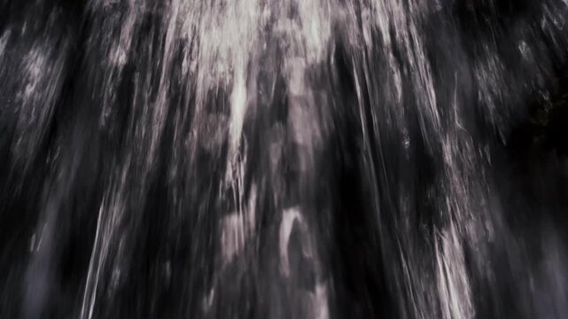 Cinematic extreme close-up of fiercely flowing water with dark bokeh background for b-roll