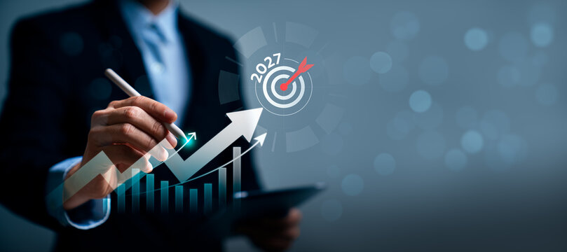 Business growth strategy concept with professional using stylus on virtual rising chart and 2027 target showing performance goals, revenue increase and future success planning
