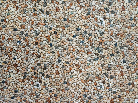 Full frame close up of small colorful washed pebble stone tile floor surface. Seamless gravel aggregate pavement texture backdrop.