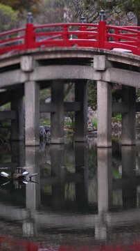 Taiko Bridge in Dazaifu Tenmangu shrine complex, Dazaifu City, Fukuoka Prefecture, Taiko-bashi arched red bridge with reflection in pond, Kyushu Island, Japan, traditional Japanese architecture