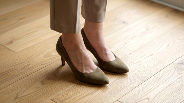 Woman wearing classic pumps on wooden floor