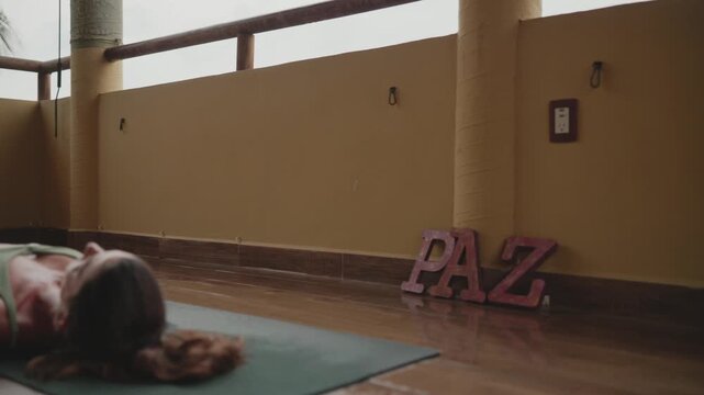 Two women relaxing in corpse pose on yoga mats at the end of a wellness retreat class