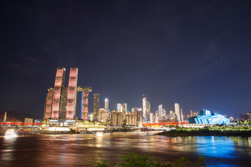 Fototapeta premium Night view of illuminated Raffles City Chaotianmen along riverside in Chongqing, China