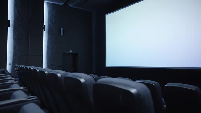 Empty cinema interior with blank white movie screen and rows of seats