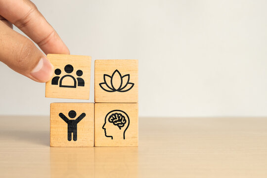 Wooden blocks showing PHYSICAL, MENTAL, SOCIAL and BALANCE icons, Representing well being, work life balance, employee wellness and holistic health concepts.
