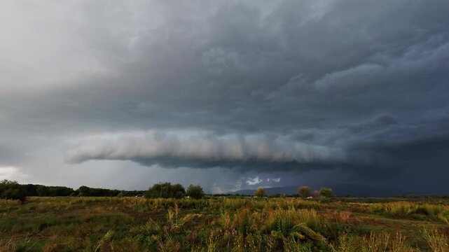 Time lapse of a storm rolling in over grassy Field in Utah as of rain moves across the valley.
