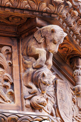 Ornate Medieval Wood Carved Corbel with Mythical Creature Lion and Human Figure on Historic Building Facade Detail © divampo