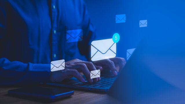 Businessman typing on laptop keyboard with glowing digital email icons. Modern technology concept for internet communication, digital business marketing, and mail message network.