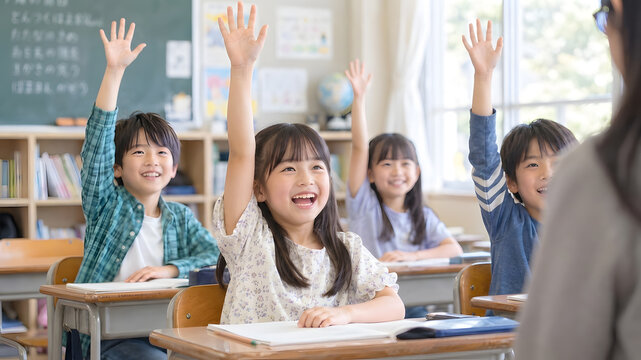 授業中に笑顔で手を挙げる日本の小学生と先生
