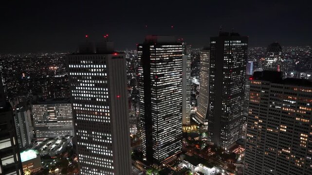 Night aerial view of illuminated skyscrapers in downtown Tokyo.