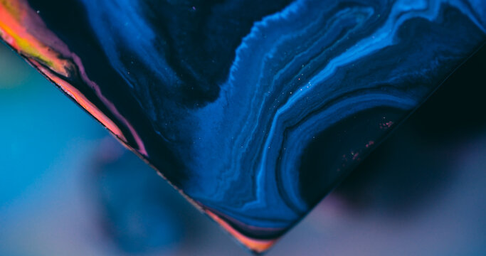 Ink spill. Sparkling fluid. Defocused blue purple color glitter triangle mix acrylic texture floating on abstract art background.