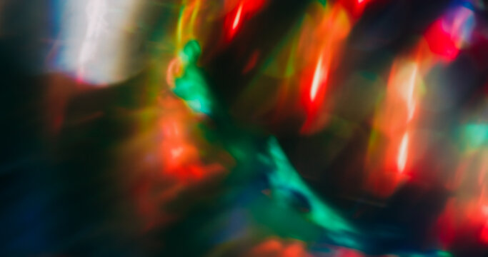 Bokeh ray. Light art. Defocused red blue multicolor radiant visual glisten optical neon glimmer texture circle on dark black background.