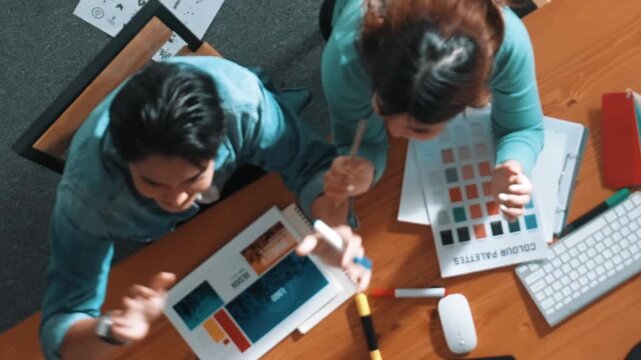 Top view of smart people throw paper and giving high five at meeting table with financial document and stock market analysis paper scattering around. Aerial view of team celebrate project. Symposium.