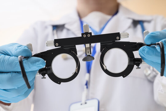 Eye examination and vision care, optometrist holding trial frame for prescription glasses in medical clinic for ophthalmology checkup and health screening
