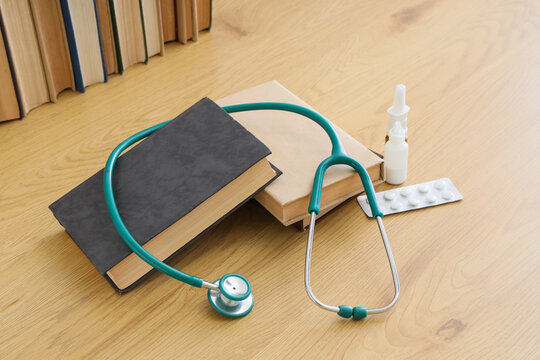 Medical education and healthcare research, stethoscope on books with medication and pills on a wooden desk for clinical study and doctor training