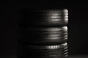 Stack of car tires on dark background © Pixel-Shot
