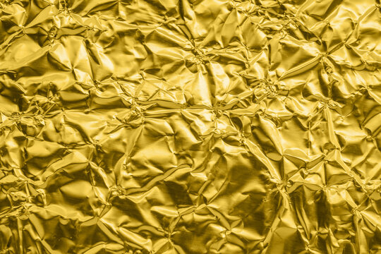 Luxury shiny metallic golden foil crumpled texture background
