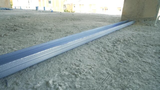 Long galvanized metal stud track lying on construction floor