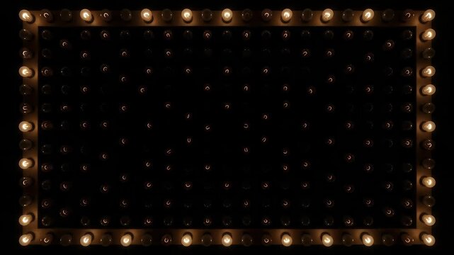 Flickering glowing rectangle animation of light bulbs on a black background. Bright seamless loop motion graphics of light film border. Stage light wall with blinking effect 
