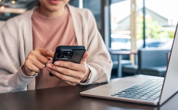 Woman using a smartphone while working. Representing digital lifestyle, mobile communication, technology and modern productivity.