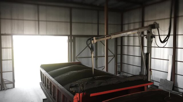 Grain sample is collected from a truck using sampling equipment for laboratory testing and quality control at an agricultural grain facility.