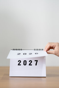 2026 to 2027 New Year Concept. Hand Turning Calendar Page Representing New Beginning, Year Transition, Future Planning, Change, Growth, Goal Setting and Fresh Start