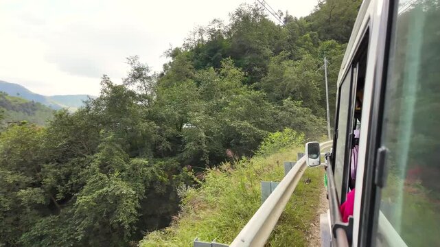 Moving Vehicle Along Narrow Mountain Road Beside Dense Forested Valley in India