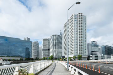 高層ビルが立ち並ぶ都市の道路と歩道 © kumagorou